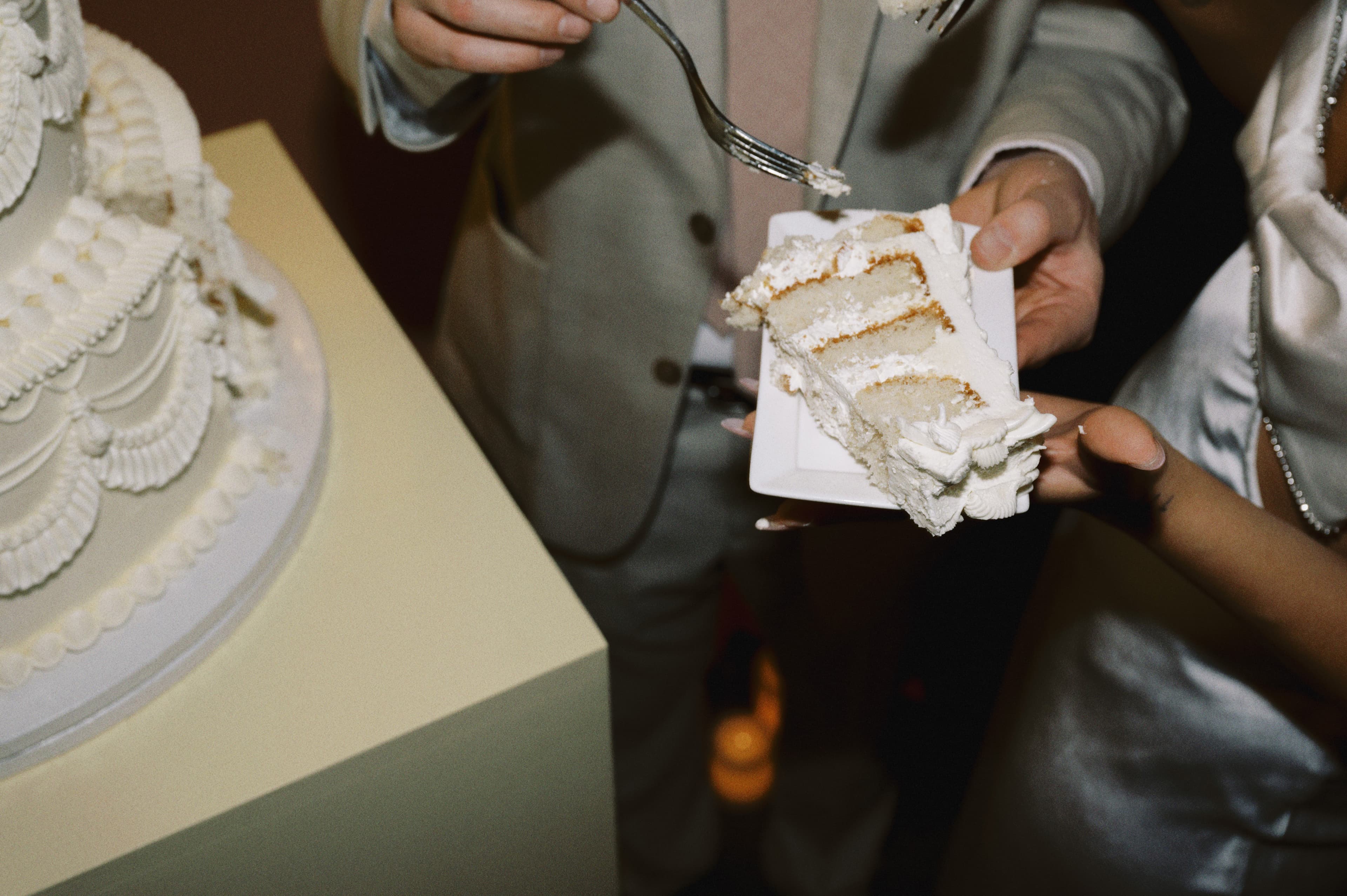 Cutting a slice of the white wedding cake