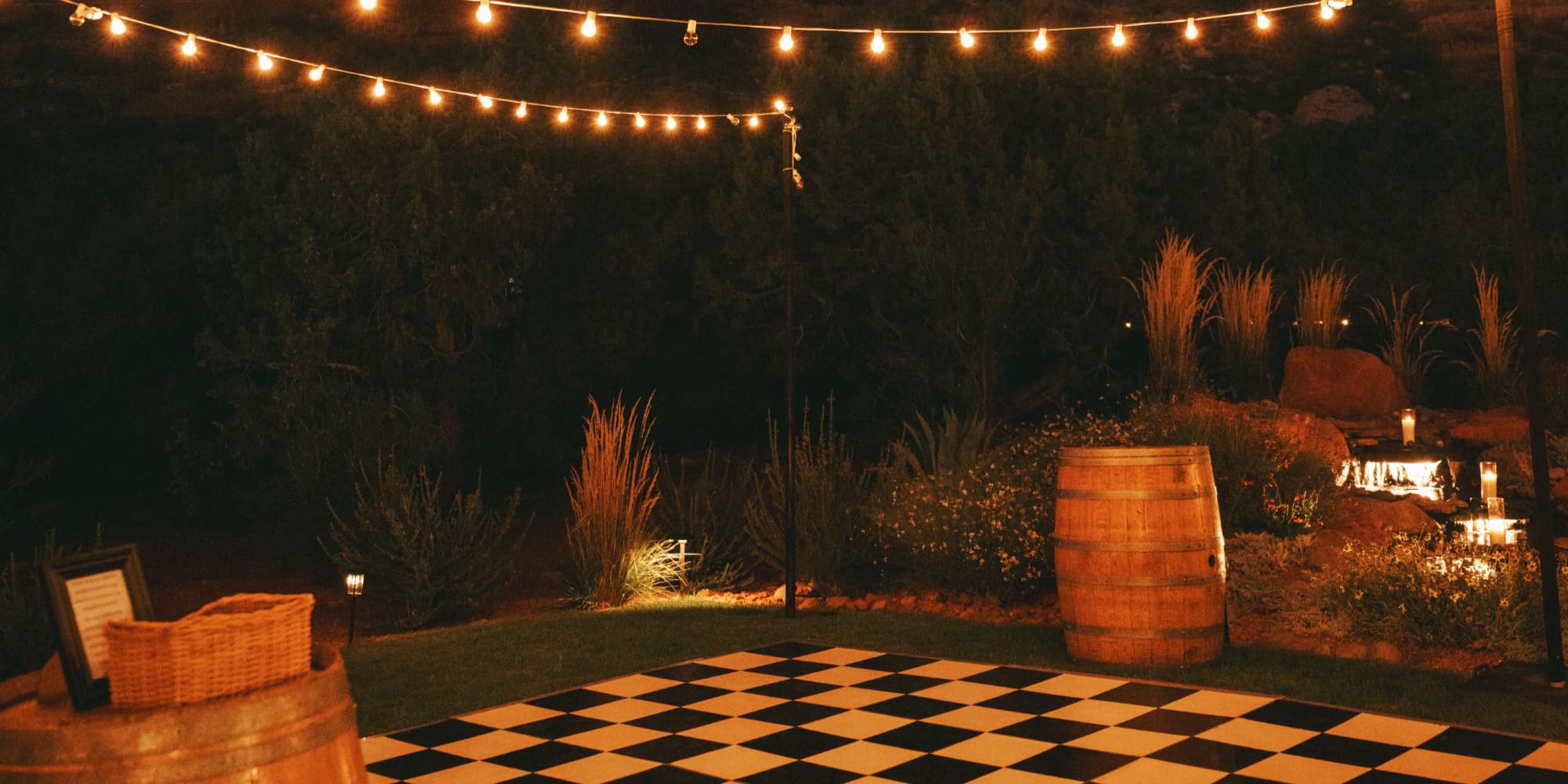 String lights over a black-and-white checkered dance floor at night