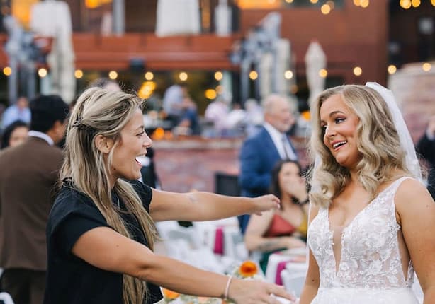 Laughing with a bride at an outdoor reception under string lights