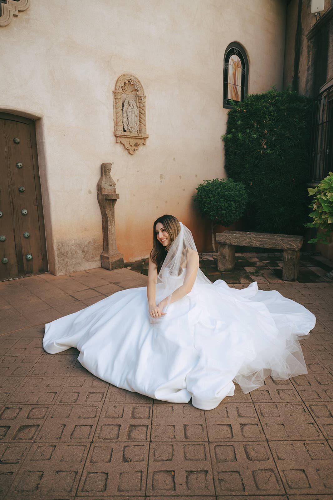 Abby seated in a sea of satin and tulle in a Tlaquepaque courtyard
