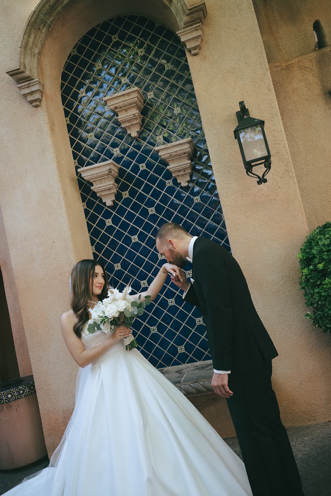 Connor kissing Abby's hand beneath the blue-tiled arch
