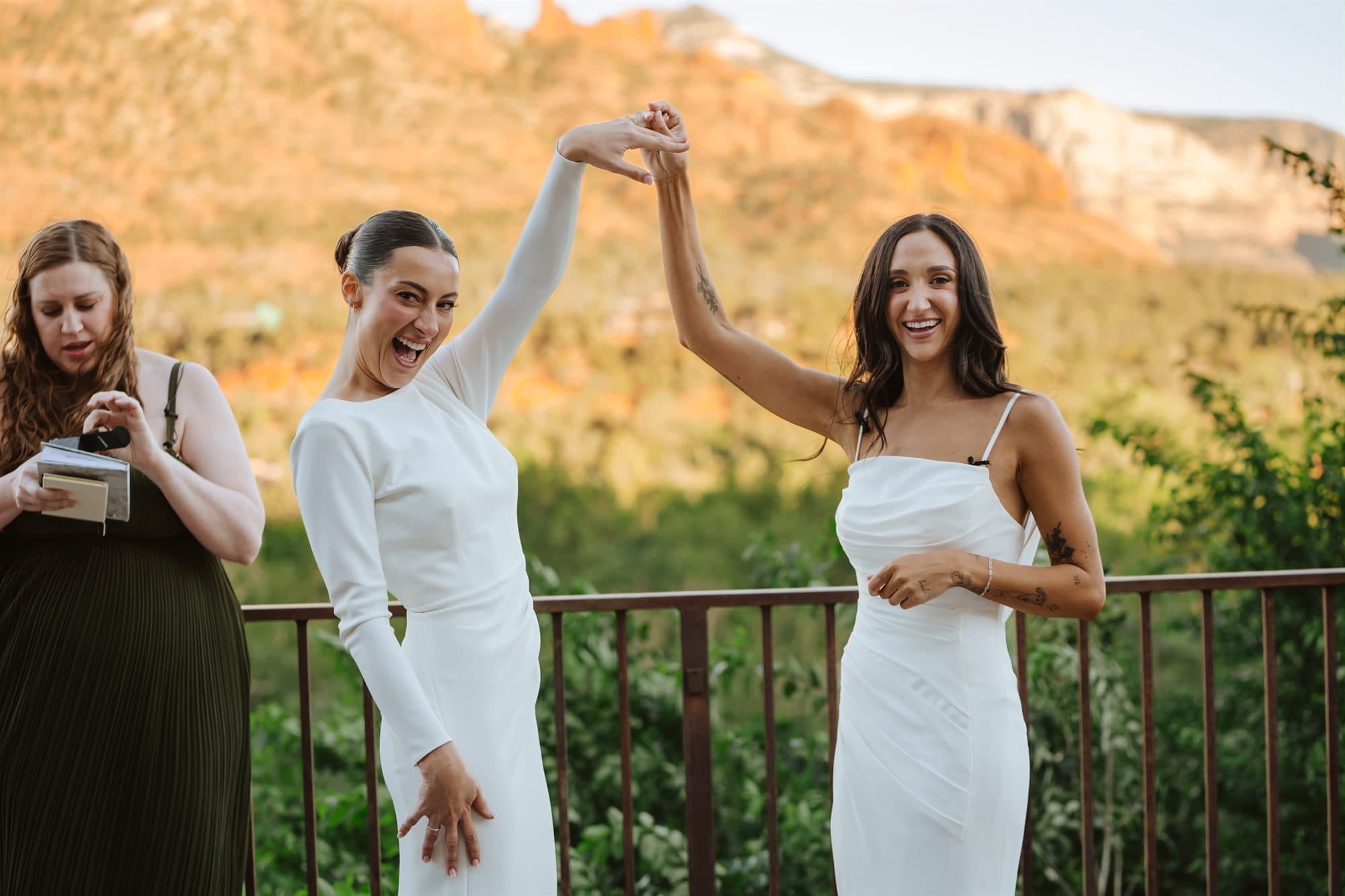 Celebrating at the end of the ceremony, hands raised before the red rocks