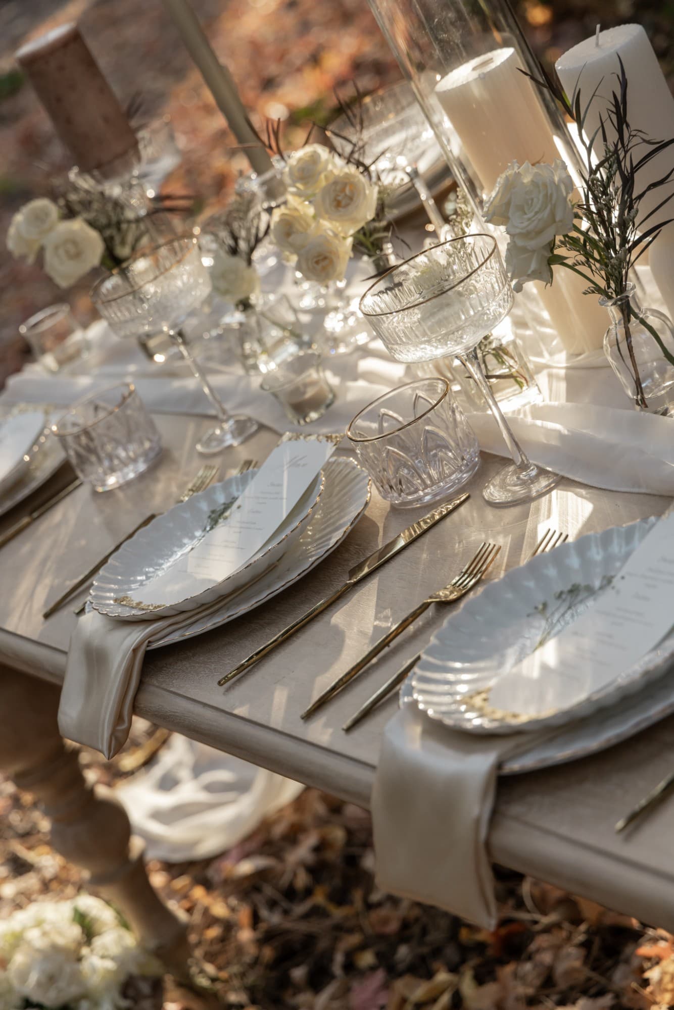 Scalloped gold-rimmed plates, custom menus, champagne napkins and gold flatware in late-afternoon sun