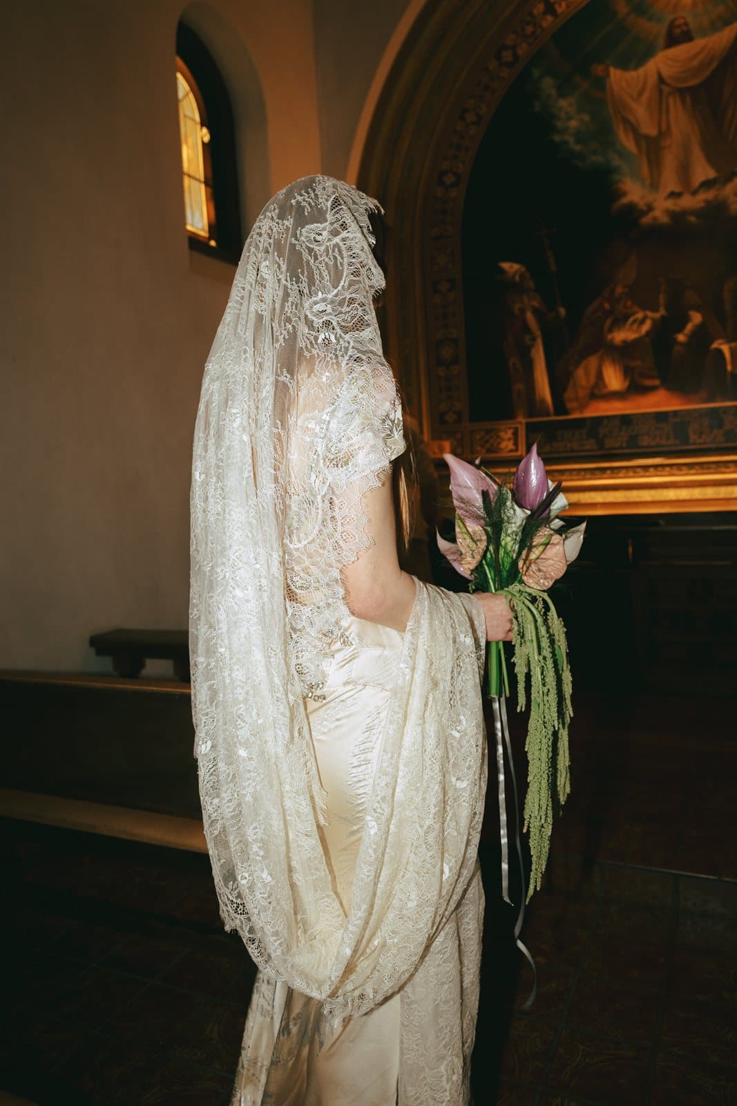 A bride in a lace mantilla before the chapel altar