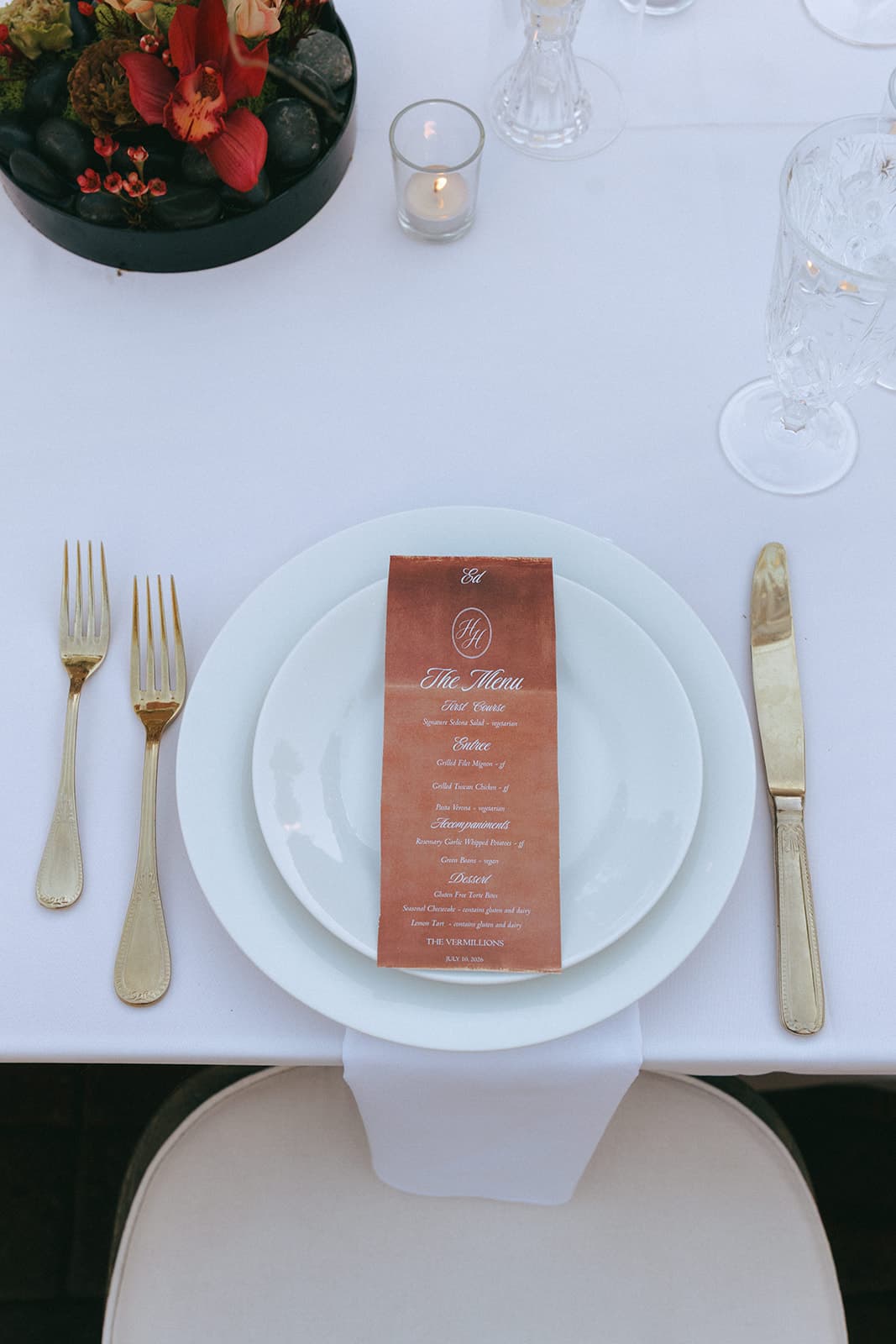 A monogrammed place setting with gold flatware