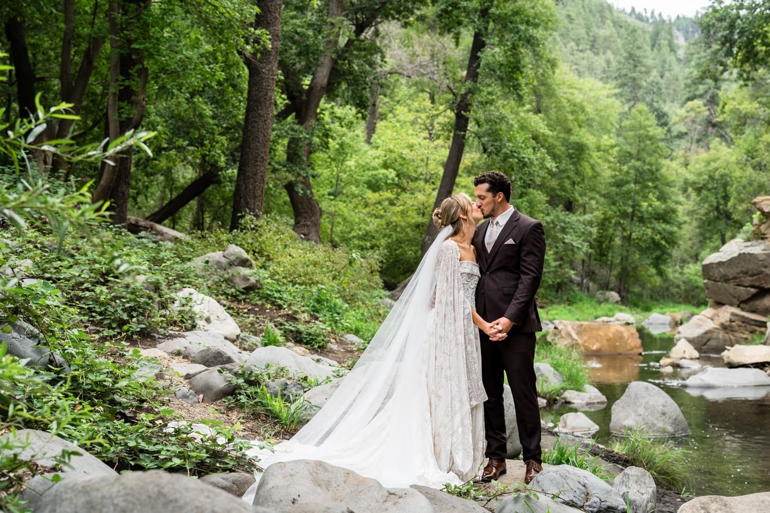 Hannah and Michael sharing a kiss on the rocks along Oak Creek
