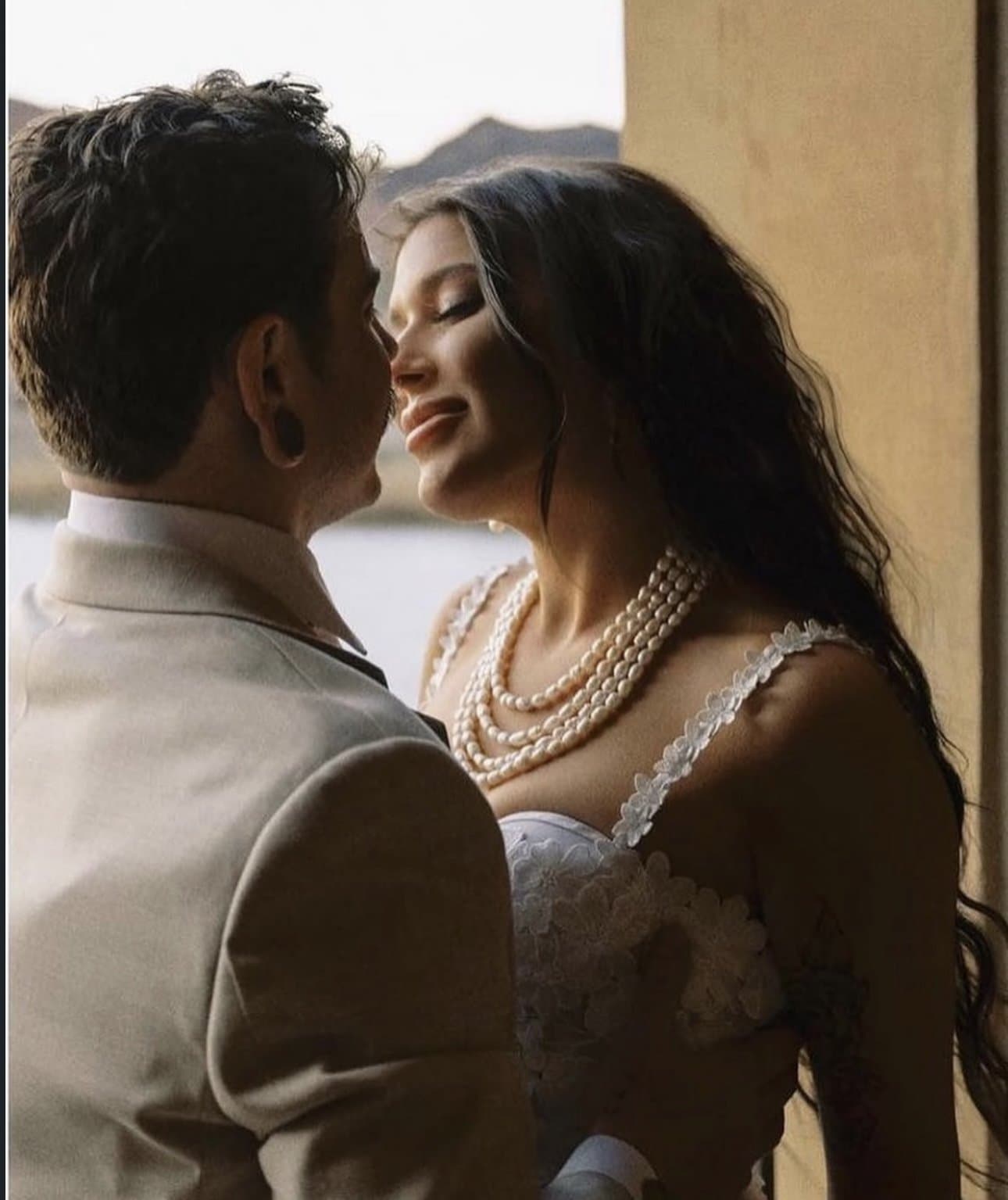 Isa and Dylan's kiss in the window light, her layered pearls catching the sun