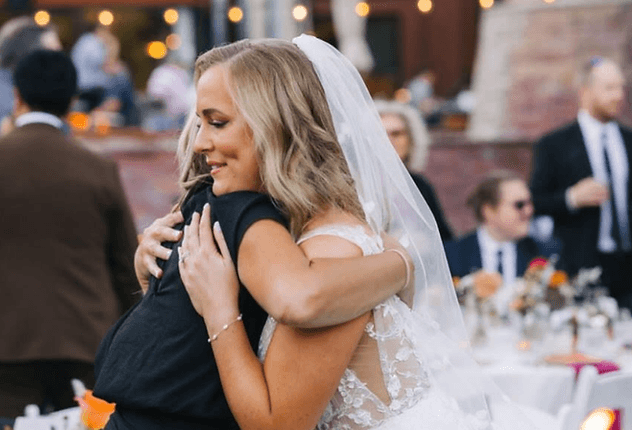 Hugging a veiled bride at a reception
