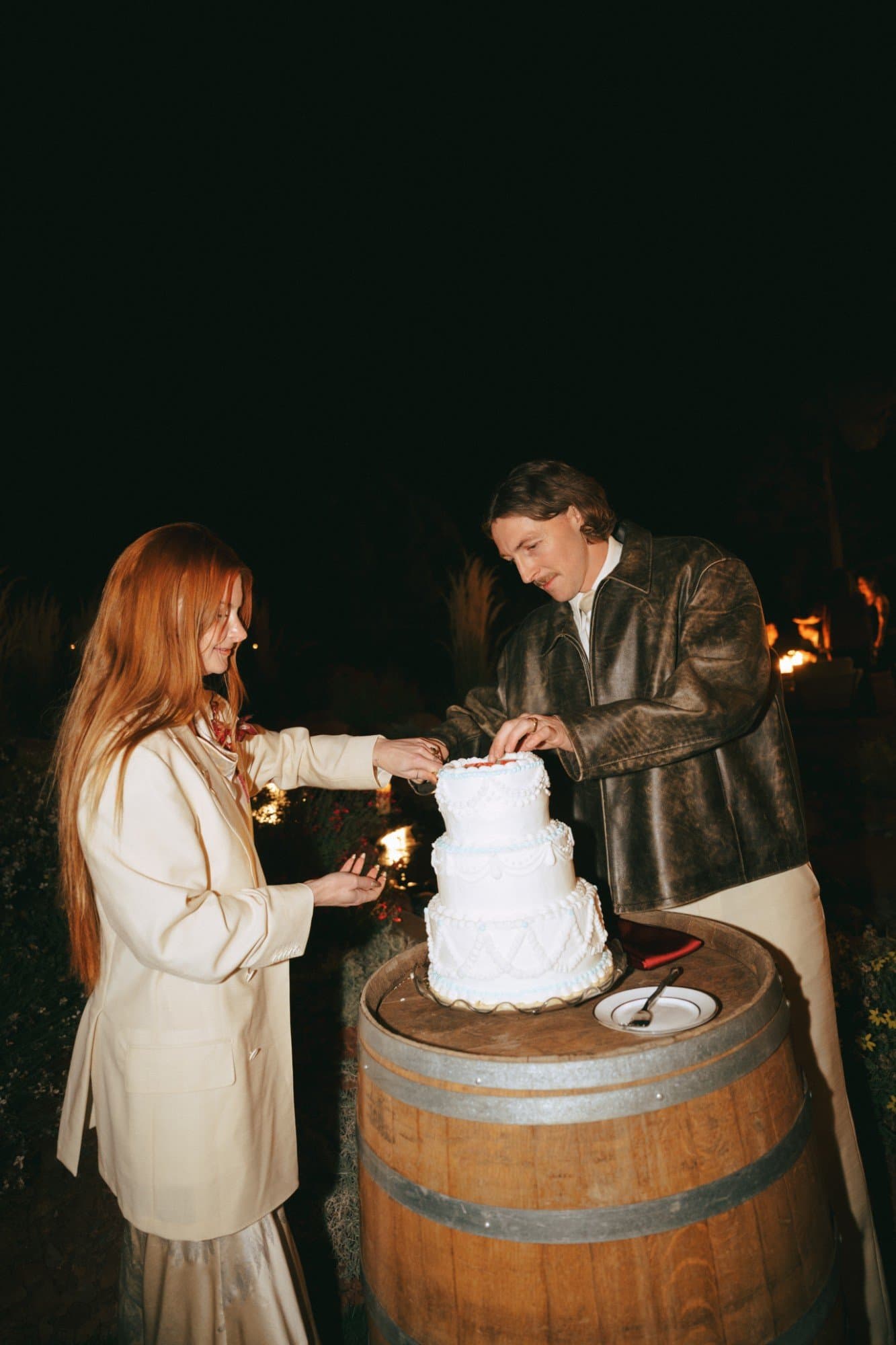 Jordan and Austin cutting their cake on a wine barrel