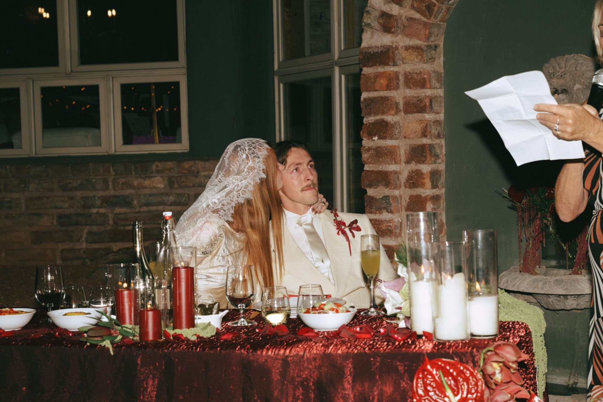 Jordan kissing Austin's cheek at the sweetheart table during the toasts