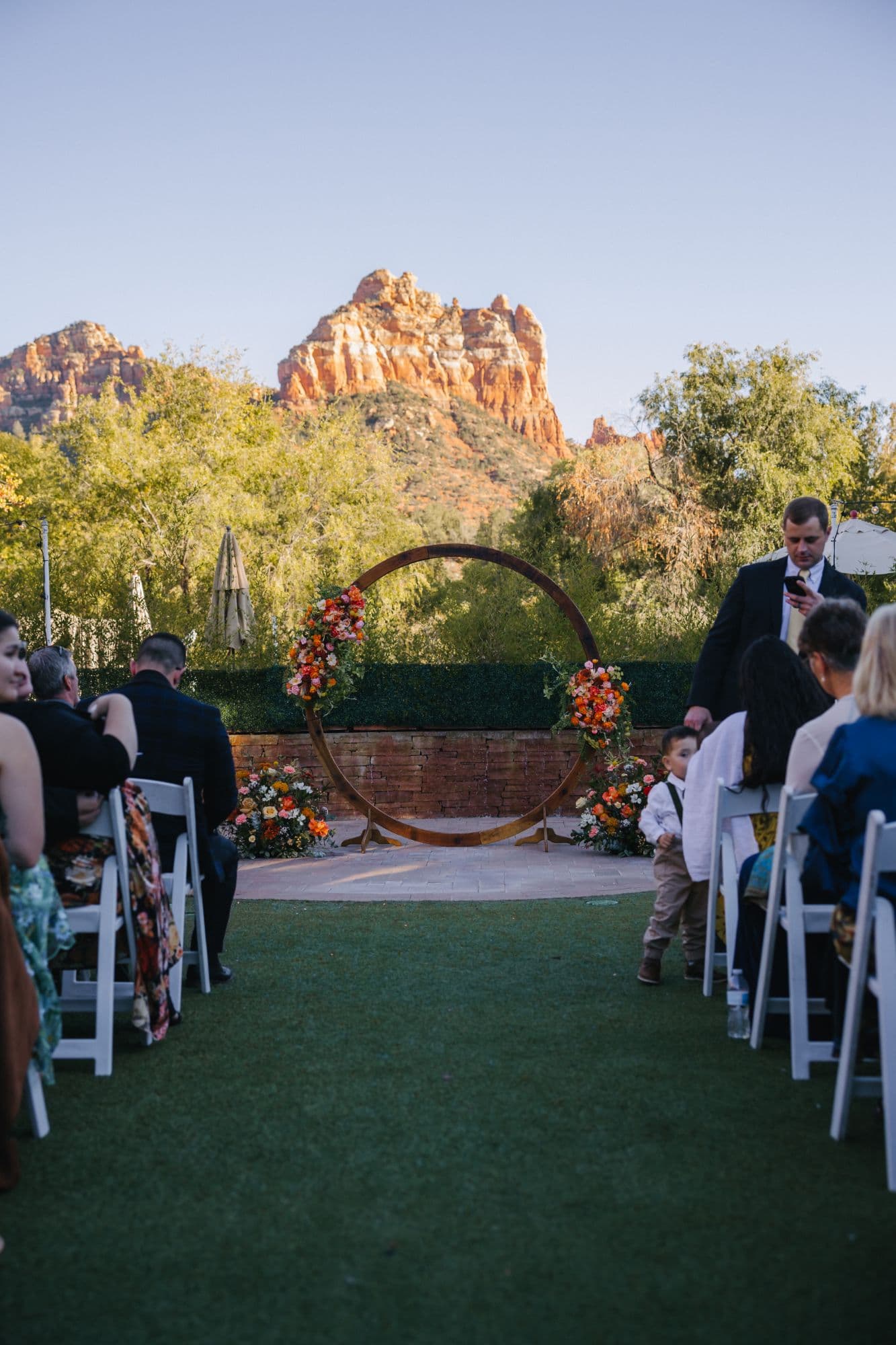 The aisle leading to the circular floral arch with the red rocks above