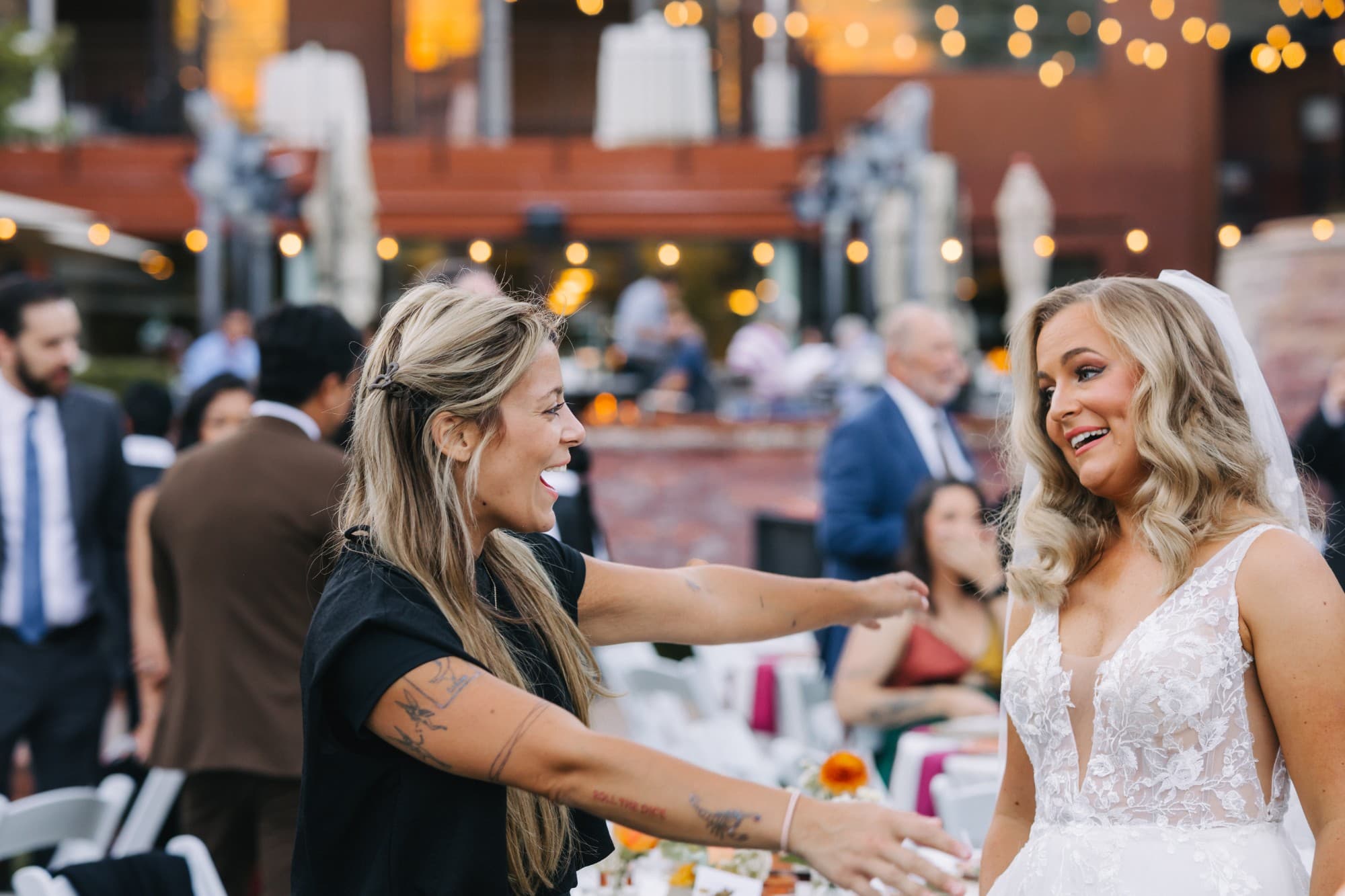 Arabella opening her arms to hug a bride at the reception