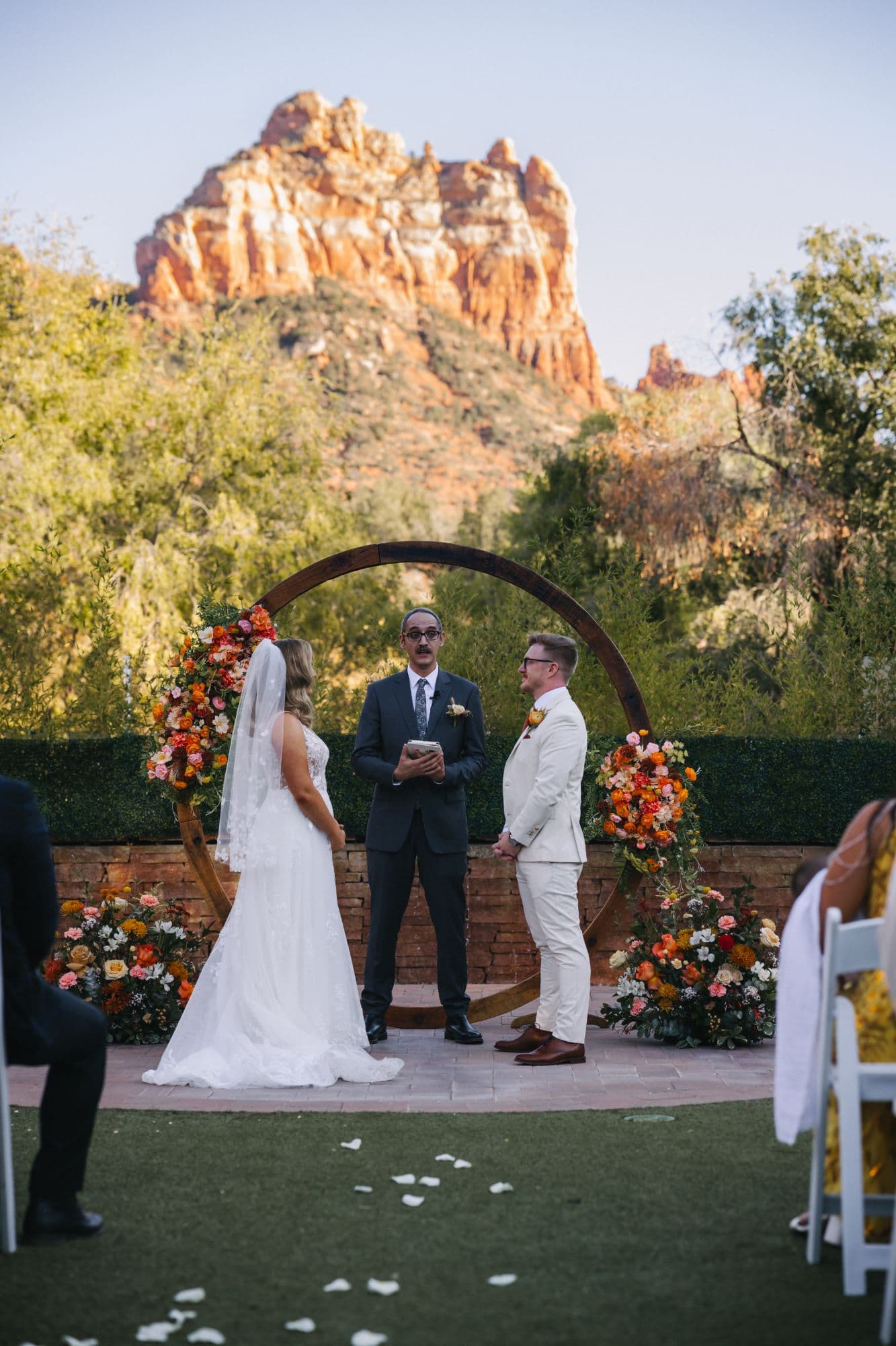 Jenna and Derek before the officiant beneath the arch