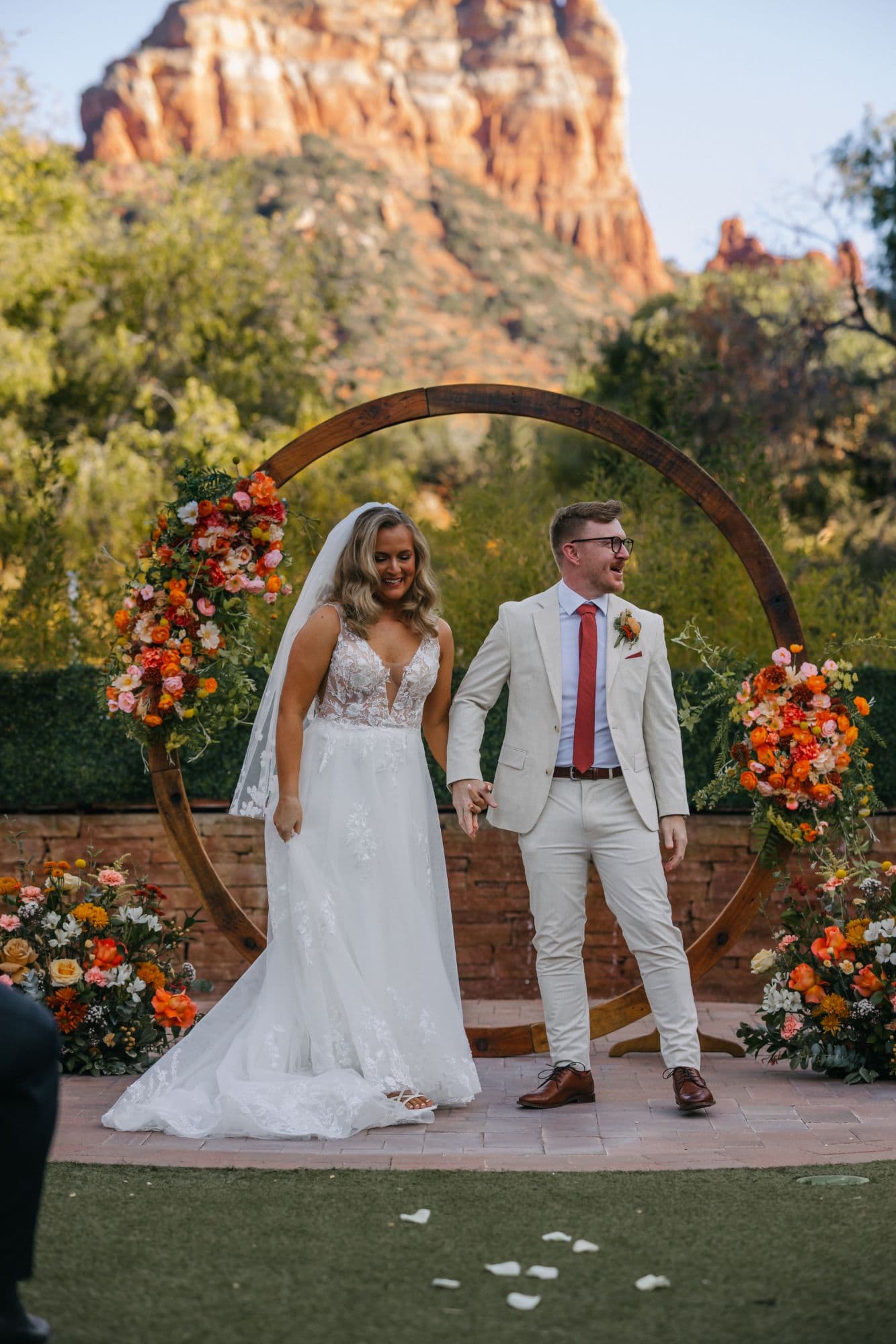 Jenna and Derek walking back up the aisle, laughing, after the ceremony