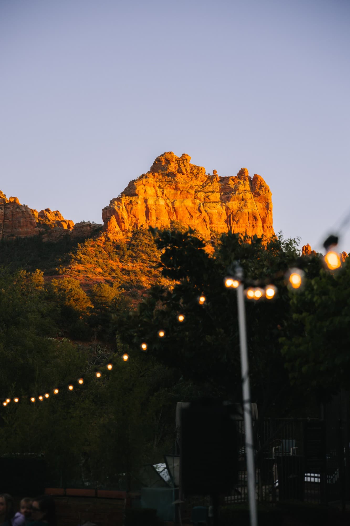 The red rocks lit gold at sunset above the string lights