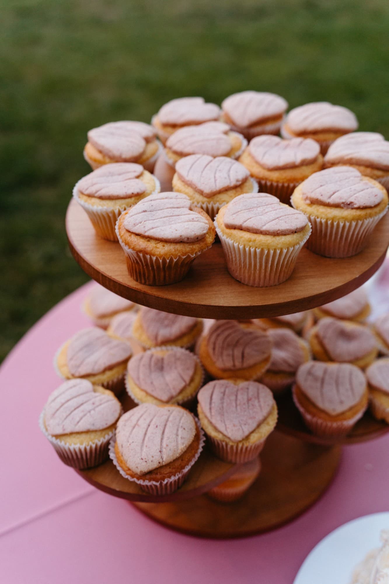 Heart-topped concha cupcakes on a wooden stand