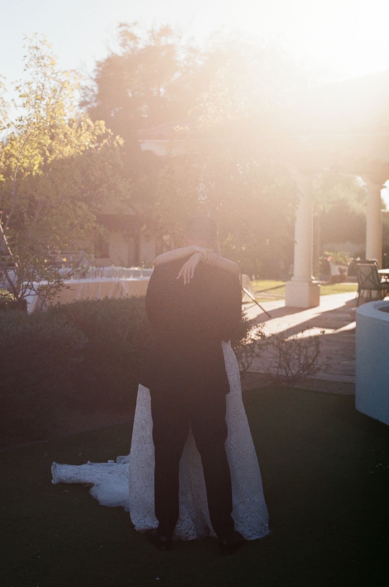 An embrace on the lawn in a haze of golden-hour light