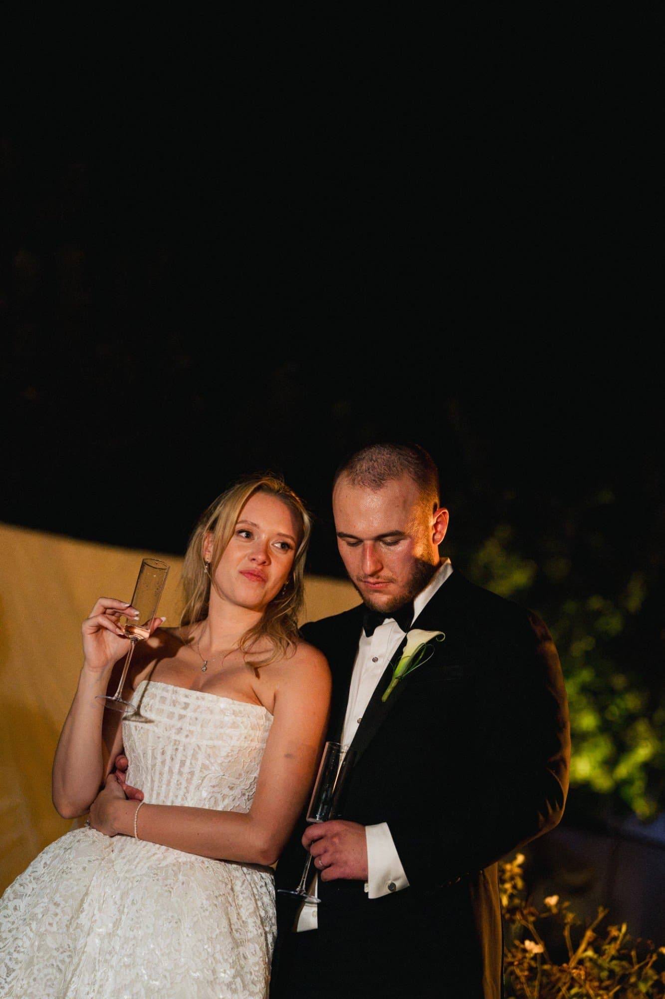 Sophia leaning into Zachary, champagne in hand, during the toasts